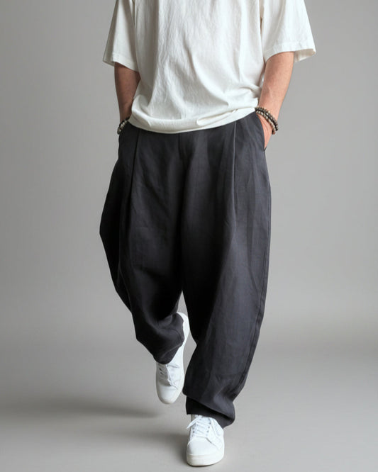 Person wearing a white shirt, MIDNIGHT black pants, and white sneakers against light grey backdrop.