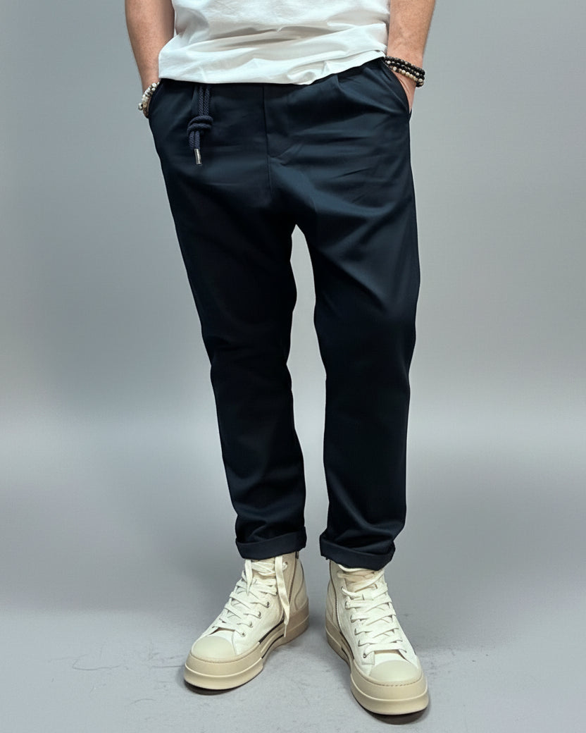 Person wearing blue pants and white high-top sneakers in a casual setting.