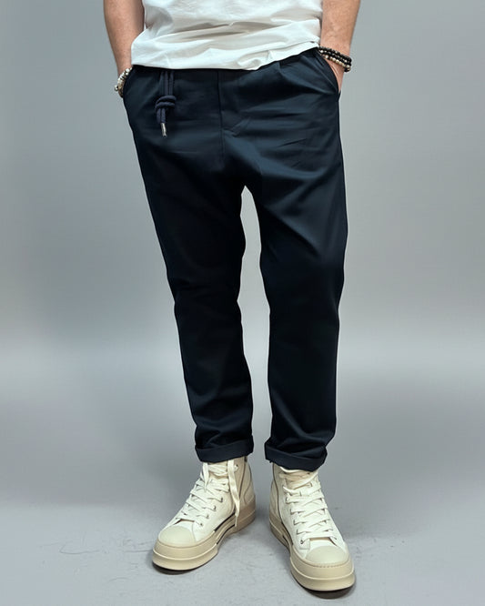 Person wearing blue pants and white high-top sneakers in a casual setting.