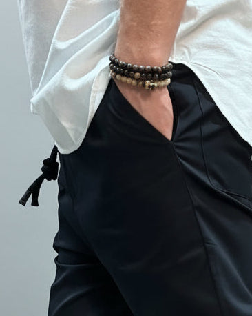 Person wearing navy blue pants and beige high-top sneakers against a dark background