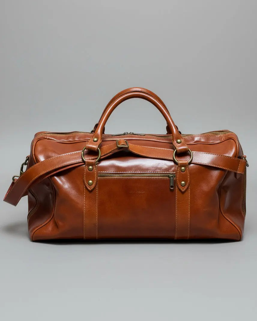 Brown leather bag with shoulder strap on a light gray fabric background