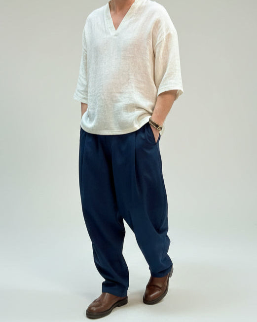 Person wearing a white shirt and blue  pants in a clothing store setting.