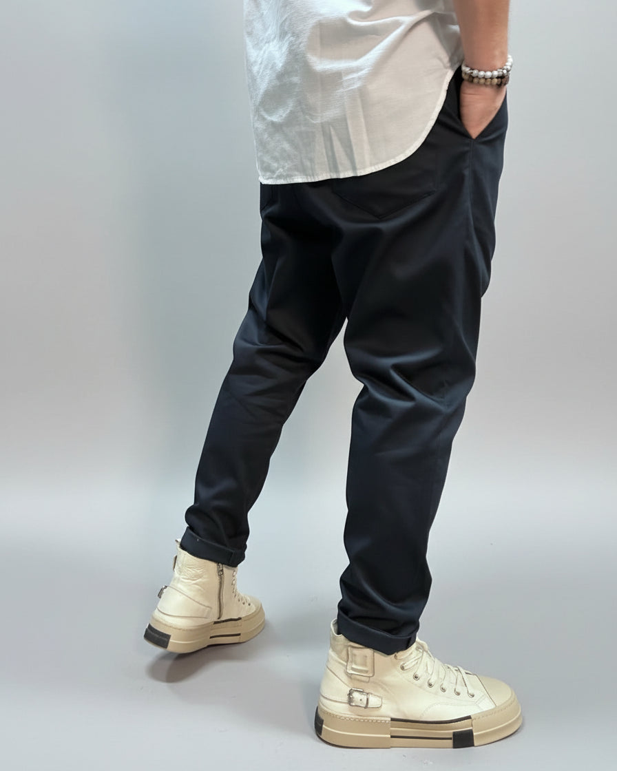 Person wearing blue pants and beige sneakers in an urban setting