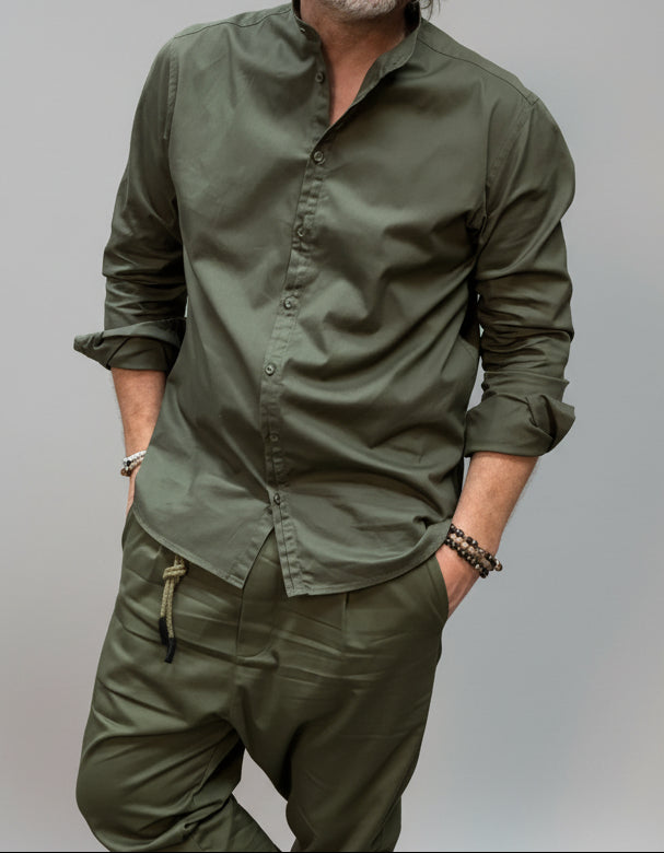 Man wearing a green korean shirt with Converse shoes in an indoor setting.