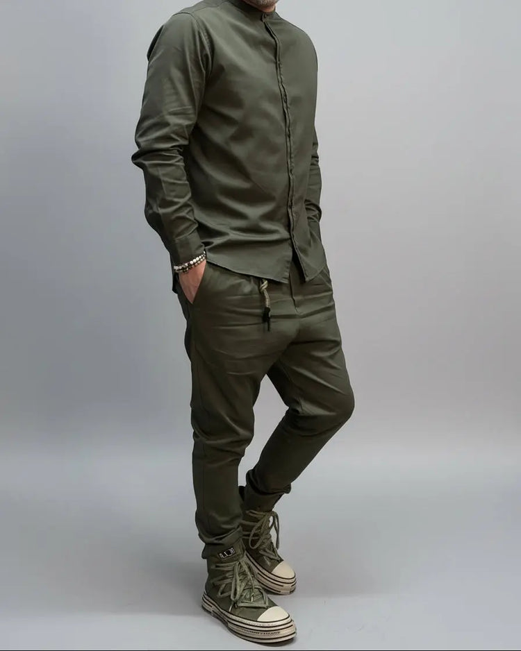 Person wearing a green outfit with matching shoes against a black metal door background