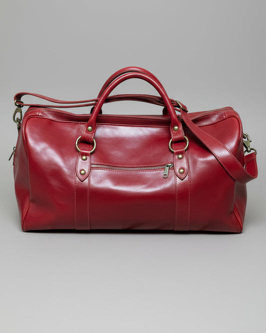 Red leather bag with a shoulder strap  on a light gray background