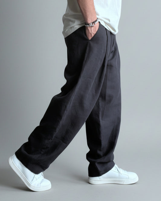 Person wearing a white shirt, MIDNIGHT black pants, and white sneakers against light grey backdrop.