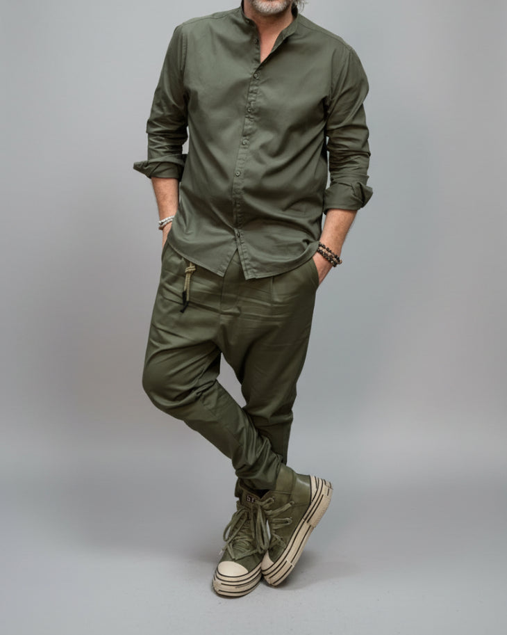 Man wearing a green outfit with Converse shoes in a studio, keep model as it is