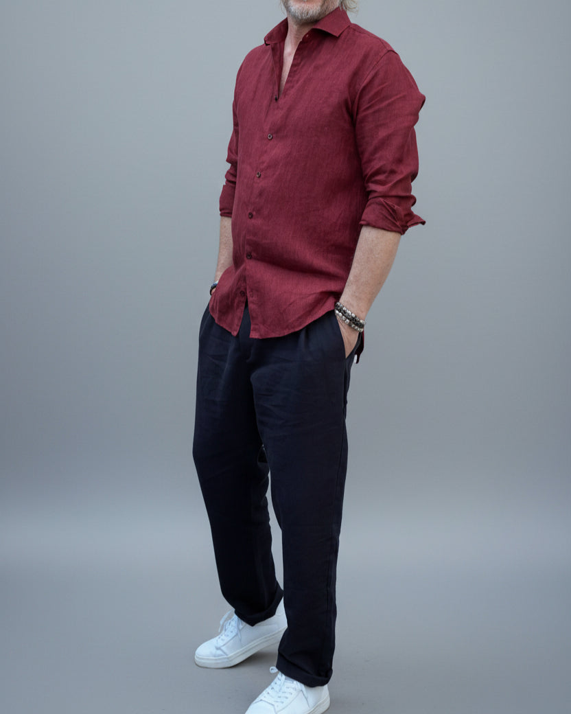 Man wearing a red shirt and sunglasses against a light grey backdrop
