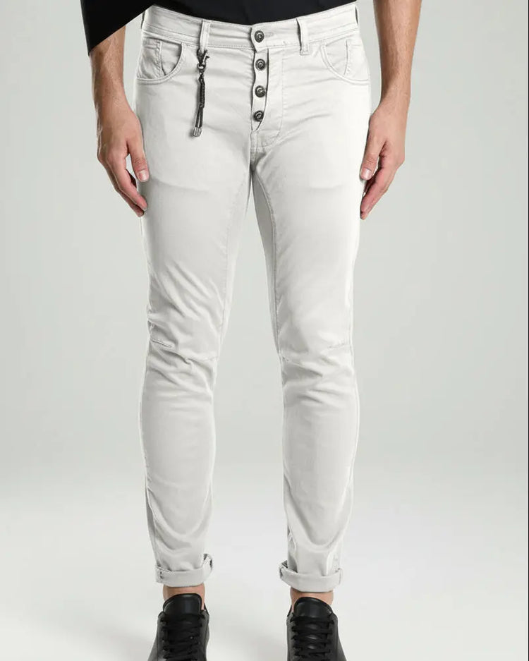 White jeans with button details worn by a person on a white background
