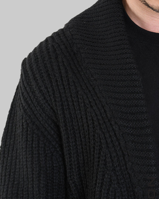 Close-up of a black knitted cardigan with a collar on a white background