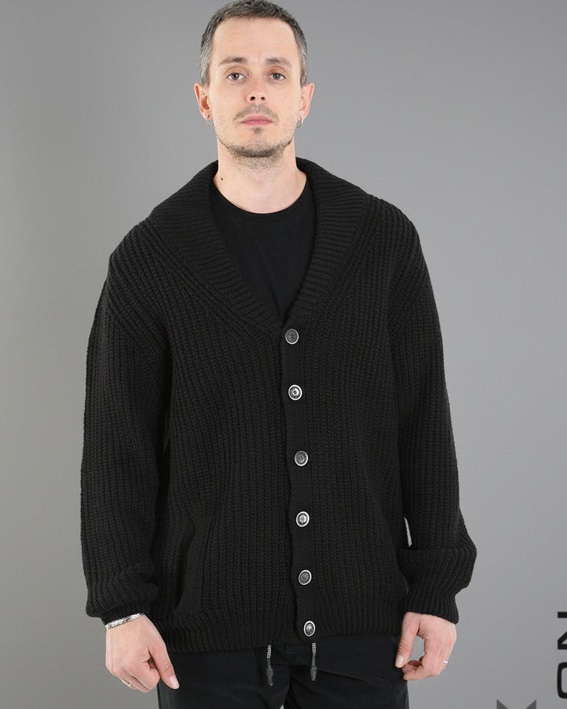 Man wearing a black ribbed cardigan with buttons on a white background