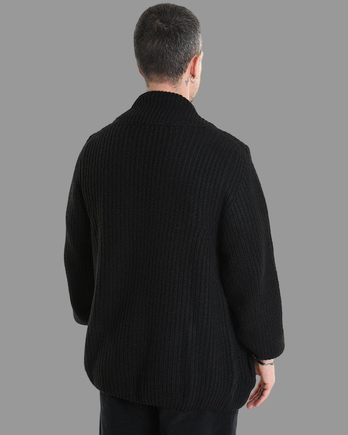 Man wearing a black ribbed sweater and pants on a white background 